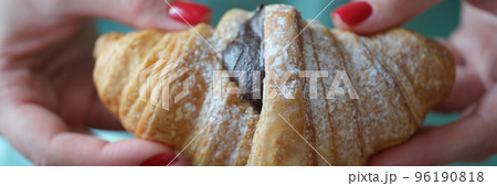 Cropped view of woman holding fresh croissant with chocolate Cropped view of woman holding fresh croissant with chocolate 96190818