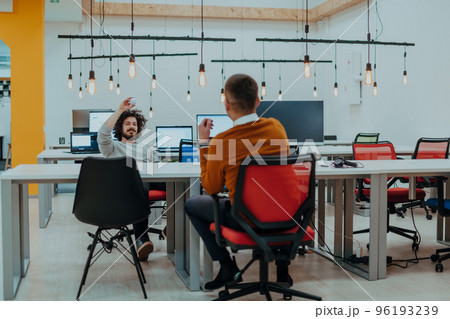 Two men having fun on a break from work in a modern office 96193239