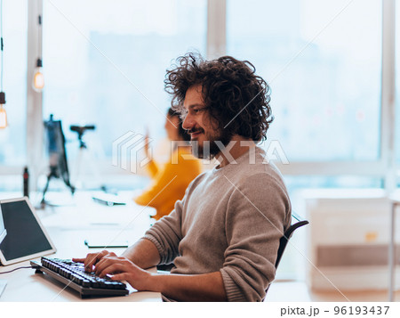 Senior developer fixing bug in fancy office. Senior developer fixing bug in fancy office. 96193437