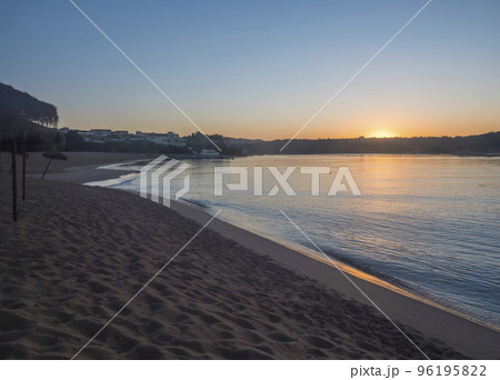 Orange sunrise at empty sand beach Praia da Franquia at Vila Nova de Milfontes with Mira river and fort Forte de Milfonte. Portugal, Rota Vicentina coast 96195822
