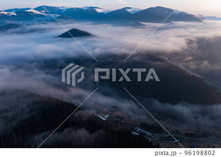 A panoramic view from above of the mountain peaks in thick clouds. A panoramic view from above of the mountain peaks in thick clouds. 96198802