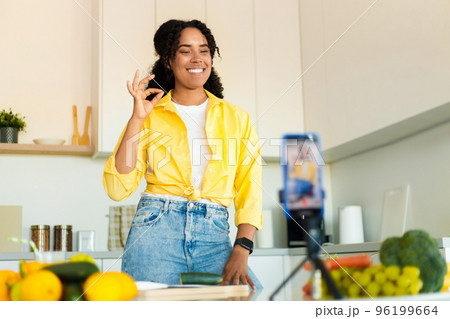 Food blogging. Excited black woman shooting on cellphone in kitchen, cooking and recording video, gesturing ok 96199664