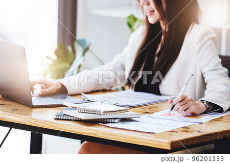 Investment concepts, businesswomen use document and computers to analyze stock markets, quantitative data collection, financial statement analysis, profitability through internet technology 96201333