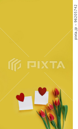 two piece of paper with red wooden heart and red tulips lies on yellow background, vertical, 16 96205742