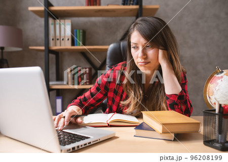 Confused woman teleworker works at home . She is in smart working due to covid-19 pandemic 96208199