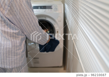 パジャマ姿の40代男性と洗濯機 96210087