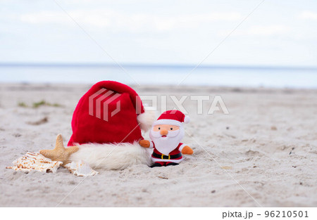 Santa Claus hat,starfish and Santa toy on the beach Santa Claus hat,starfish and Santa toy on the beach 96210501