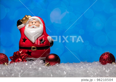 Ceramic Santa Claus statue and christmas tree toys standing on snow  96210504