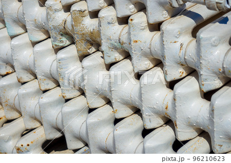 Old cast iron batteries or heating radiators stacked. Scrap metal and recyclables. Background close-up. Old cast iron batteries or heating radiators stacked. Scrap metal and recyclables. Background close-up. 96210623