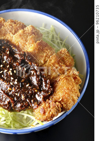 キャベツもたっぷり敷かれている熱々味噌カツ丼を黒背景で俯瞰撮影 キャベツもたっぷり敷かれている熱々味噌カツ丼を黒背景で俯瞰撮影 96210735