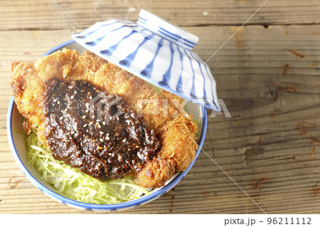 キャベツもたっぷり敷かれている熱々味噌カツ丼を俯瞰で撮影 96211112