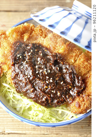 キャベツもたっぷり敷かれている熱々味噌カツ丼を俯瞰で撮影 96211120