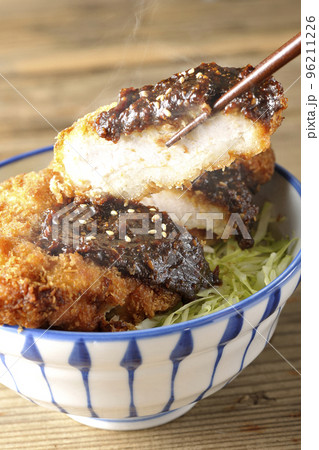 キャベツもたっぷり敷かれている熱々味噌カツ丼を食べる キャベツもたっぷり敷かれている熱々味噌カツ丼を食べる 96211226