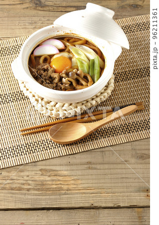 牛肉、しめじ、長葱、カマボコ、卵黄が入っている味噌煮込みうどん 96211361