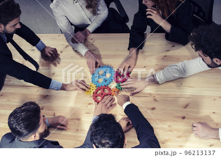 Business team connect pieces of gears. Photo from above. Teamwork, partnership and integration concept Business team connect pieces of gears. Photo from above. Teamwork, partnership and integration concept 96213137