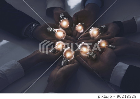 Teamwork and brainstorming concept with businessmen that share an idea with a lamp. Concept of startup Teamwork and brainstorming concept with businessmen that share an idea with a lamp. Concept of startup 96213528