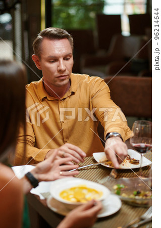 Serious man asking wife if she will finish her salad 96214644