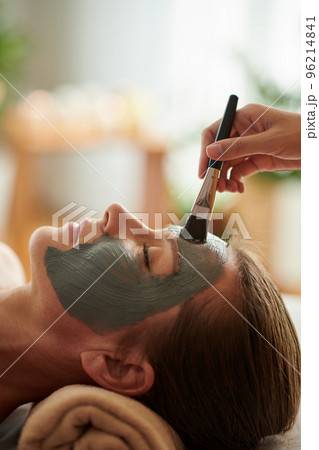 Mature woman getting clay mask spa treatment in beauty salon Mature woman getting clay mask spa treatment in beauty salon 96214841