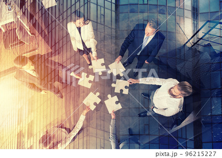 Teamwork of partners. Concept of integration and startup with puzzle pieces Teamwork of partners. Concept of integration and startup with puzzle pieces 96215227