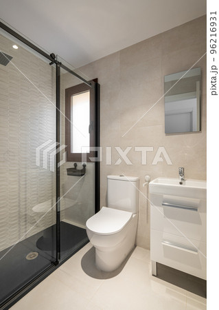 Modern empty bathroom with beige tiles, furniture and rectangular mirror Modern empty bathroom with beige tiles, furniture and rectangular mirror 96216931