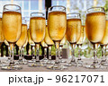 Glasses for champagne stand on the table in front of the buffet 96217071