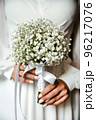 a beautiful white bouquet is held in the hands of a girl in a beautiful white dress 96217076