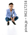 A 10-year-old Asian boy in a casual jacket is sitting smart and happy looking at the camera against a white isolate background. 96217258