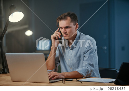 young entrepreneur making a night call from his office. young entrepreneur making a night call from his office. 96218485
