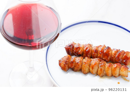 炭火でじっくり焼いた焼き鳥のぼんじり（タレ）と赤ワインのグラス 96220131