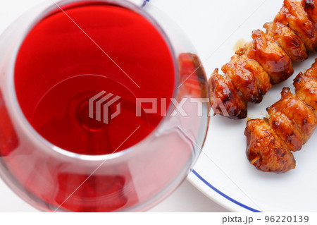 炭火でじっくり焼いた焼き鳥のぼんじり（タレ）と赤ワインのグラス 96220139