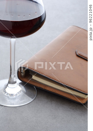 茶色の革のシステム手帳と赤ワインのグラス 茶色の革のシステム手帳と赤ワインのグラス 96221046