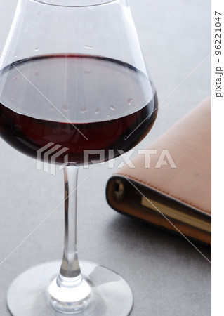 茶色の革のシステム手帳と赤ワインのグラス 茶色の革のシステム手帳と赤ワインのグラス 96221047