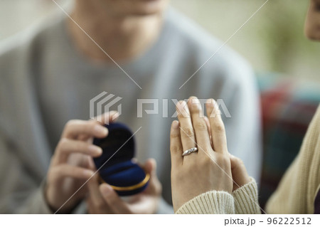 プロポーズイメージ　指輪をはめるカップルの手元 96222512