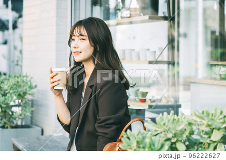 屋外でコーヒーを飲む女性 96222627