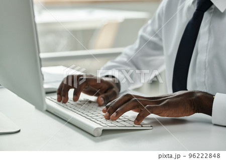 Close-up of African American businessman typing on keyboard while working on computer at office 96222848