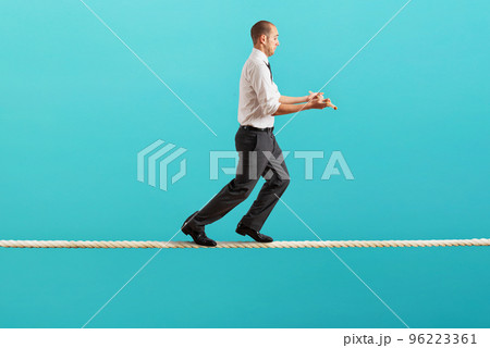 Worry man in balance walking on a rope Worry man in balance walking on a rope 96223361