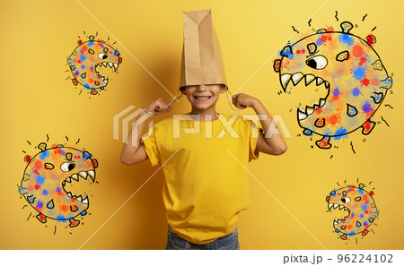 Child is afraid due to covid19 virus attack and hides his head inside a shopping bag Child is afraid due to covid19 virus attack and hides his head inside a shopping bag 96224102
