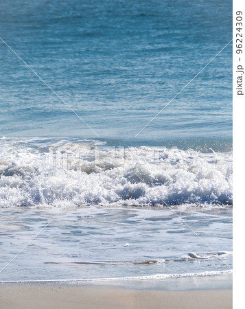 砂浜に打ち寄せる白波と青い海。 96224309