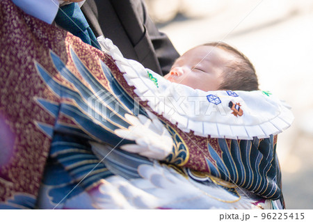 お宮参り(初宮詣)のお祝いでおじいちゃんに抱かれる赤ちゃん 96225415