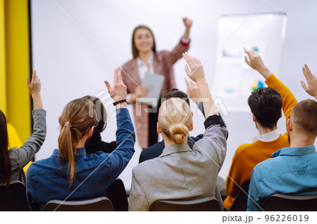 Business people raising hand up to ask question with speaker Business people raising hand up to ask question with speaker 96226019