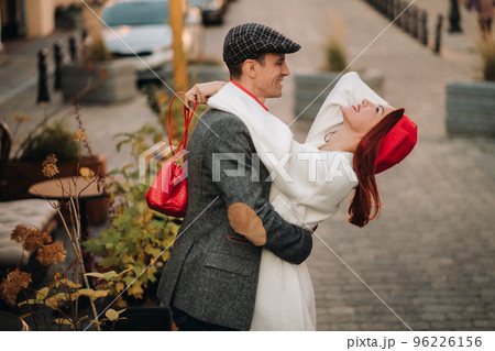 Portrait of a happy couple hugging on the street in an autumn city. Retro stylish couple in autumn in the city Portrait of a happy couple hugging on the street in an autumn city. Retro stylish couple in autumn in the city 96226156