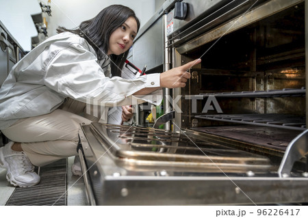 厨房を確認する若い女性　ガスオーブン 96226417