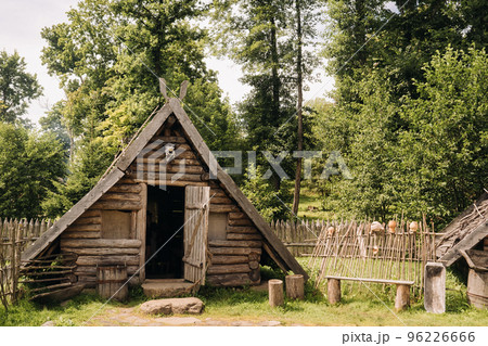 Triangular log houses with wooden roofs behind a fence. Montenegro, north Triangular log houses with wooden roofs behind a fence. Montenegro, north 96226666