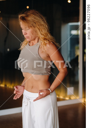 a woman does breathing exercises in the fitness room. Home sports training for the muscles of the press 96227096
