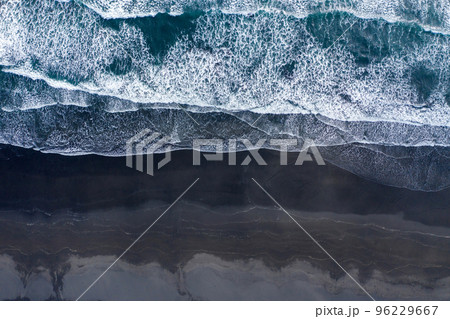 Aerial view of Atlantic ocean waves washing black sandy beach 96229667