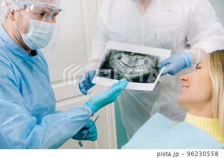 Dentist explaining the details of the X-ray to his patient in the office 96230558