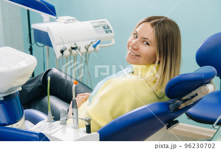The girl smiles at the dentist and looks at her The girl smiles at the dentist and looks at her 96230702