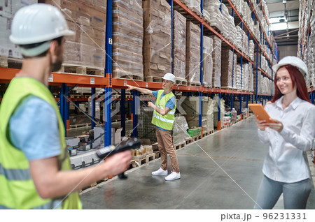 Storehouse workers working supervised by an inspector 96231331