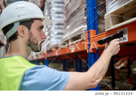 Young man in a protective helmet working in a warehouse 96231334
