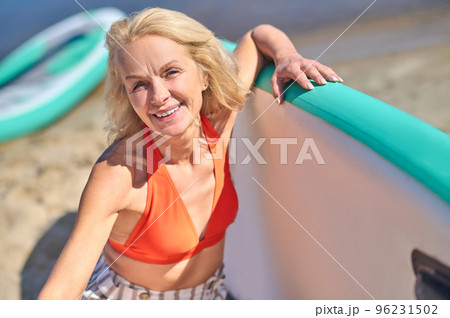 Smiling blonde woman on the beach looking contented 96231502